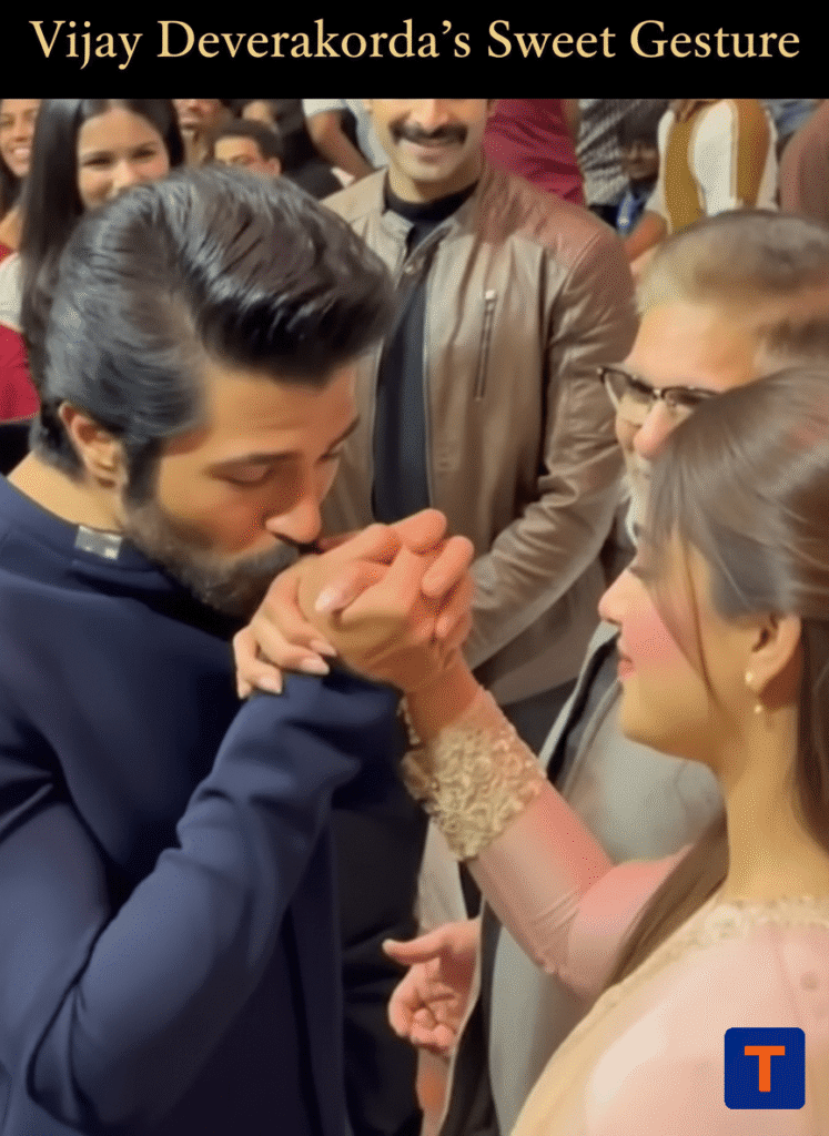 Rashmika Mandanna blushes as Vijay Deverakonda kisses her hand at an event.